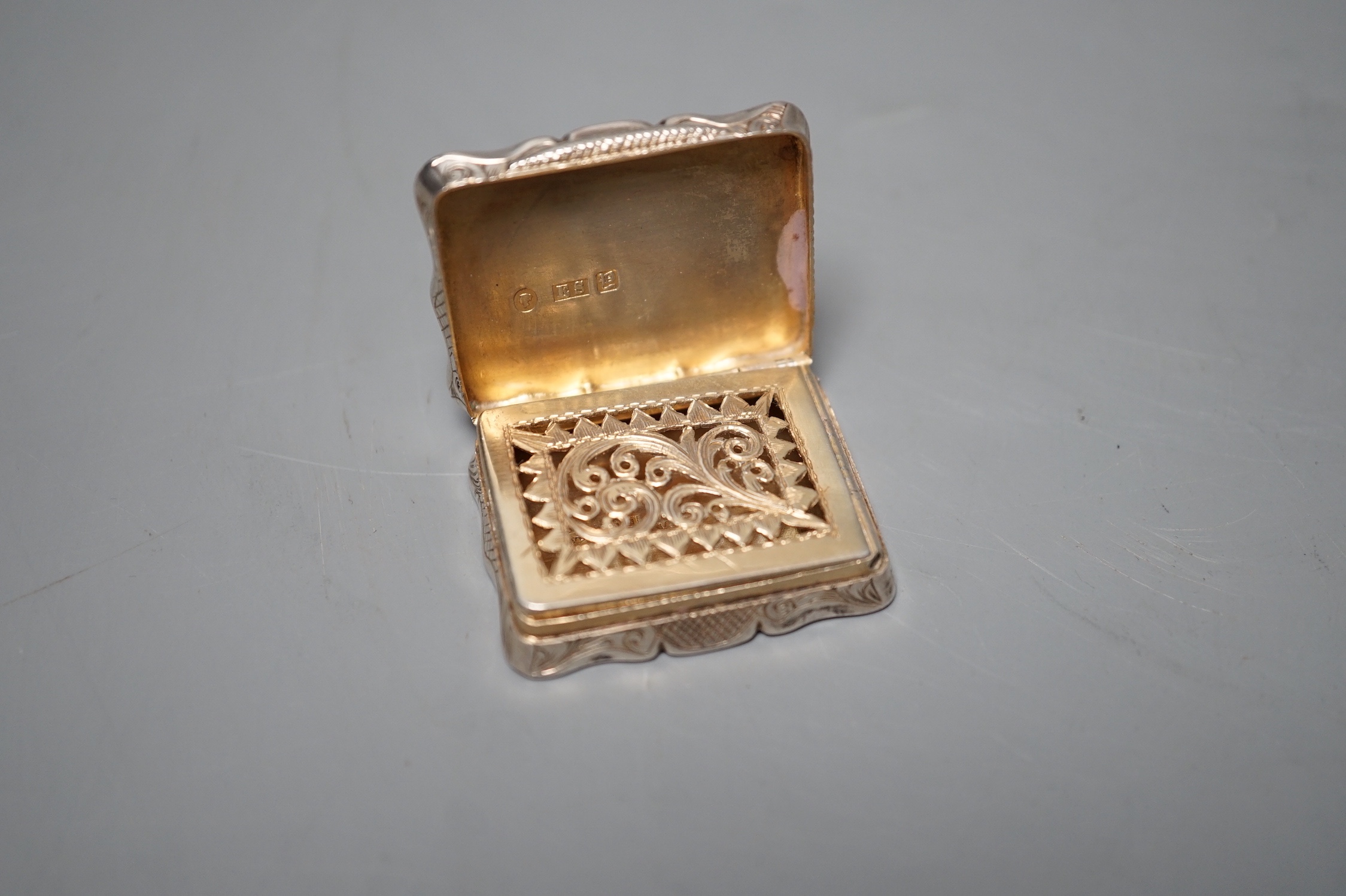 A Victorian silver shaped rectangular vinaigrette, engraved with landscape scene with river, Edward Smith, Birmingham, 1847, 38mm.